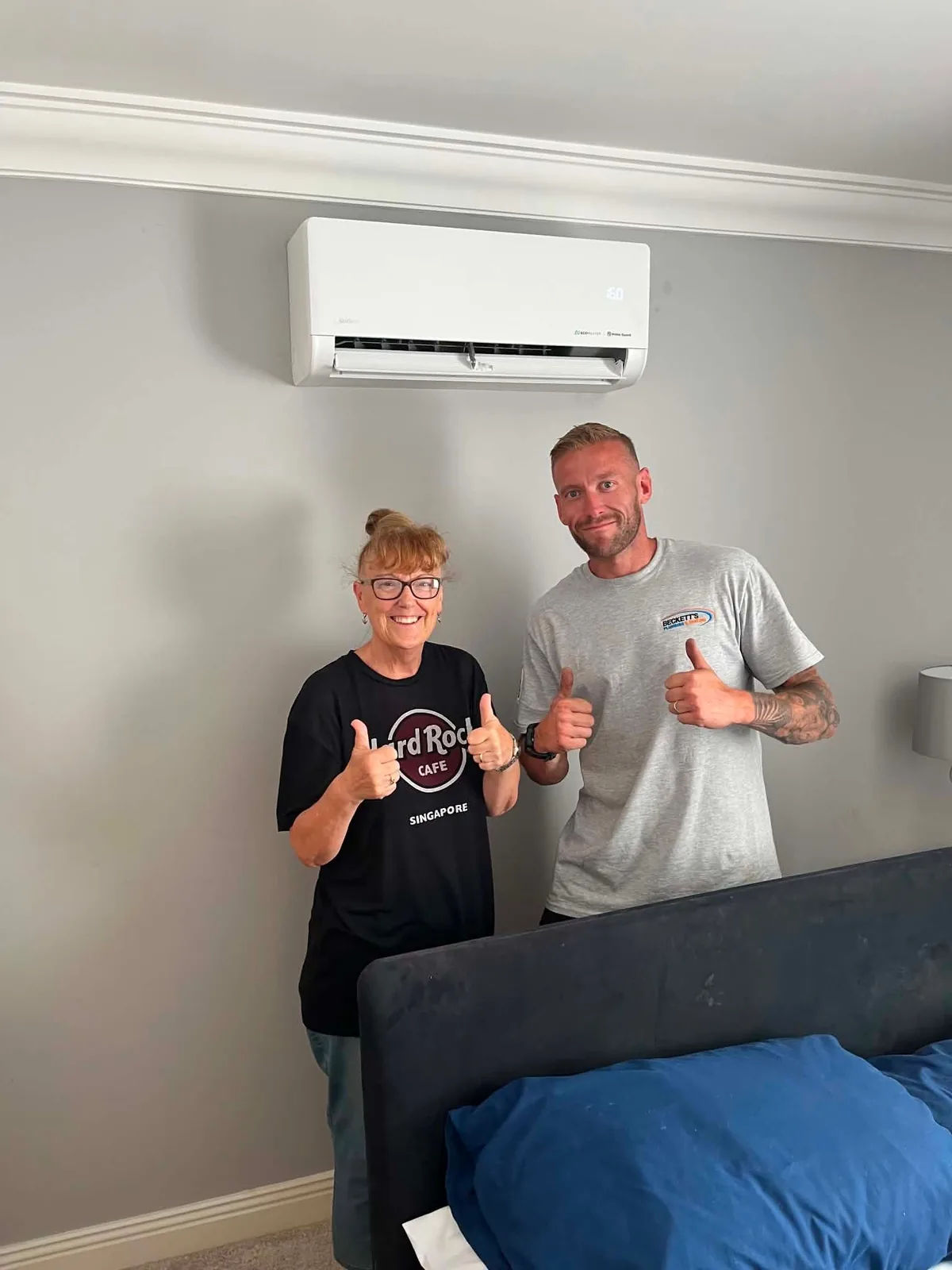 Happy customer with Sam after an air conditioning installation in a Southampton bedroom