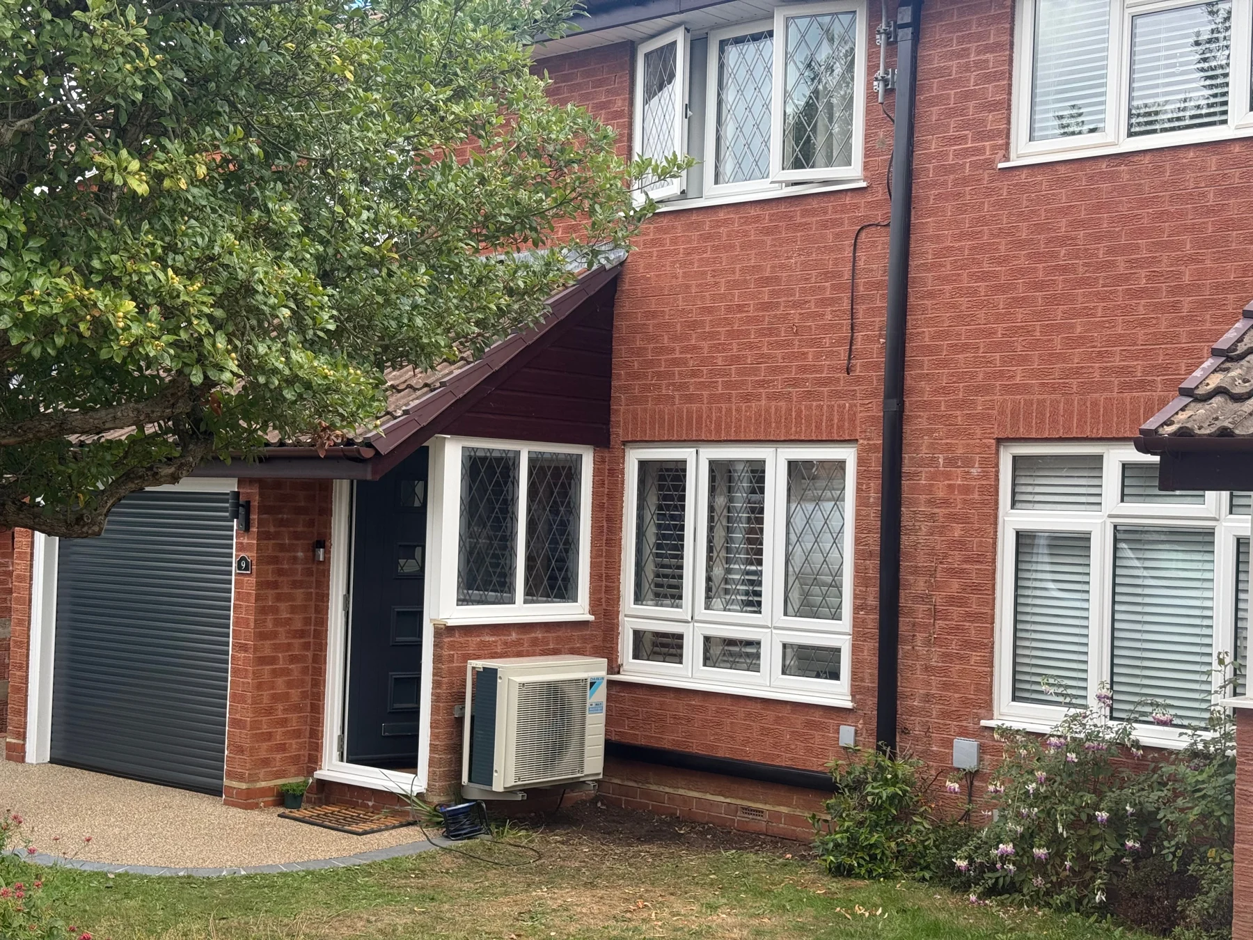 Air conditioning condenser neatly fitted on a house exterior